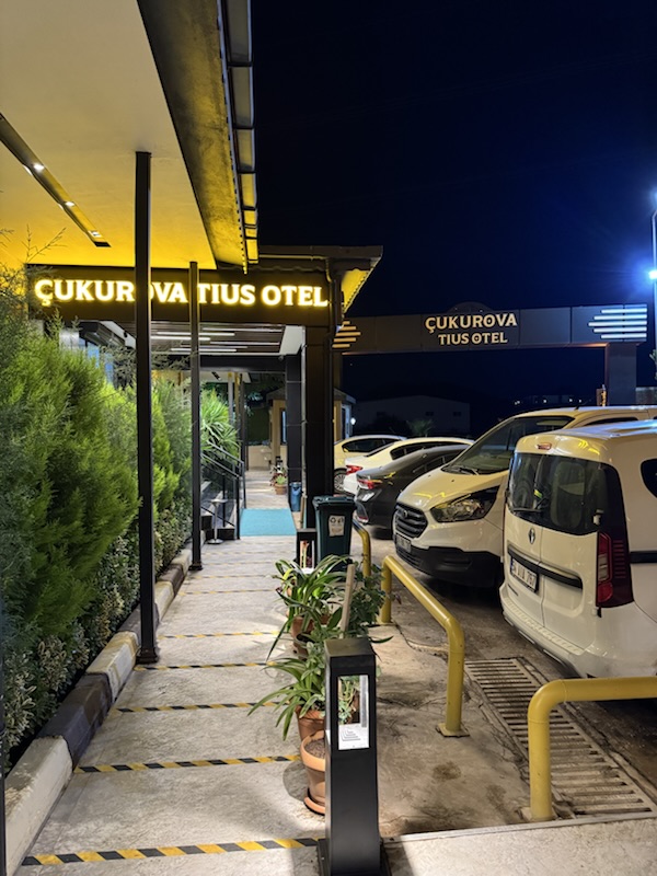 Gece ışıklı Çukurova Tius Otel tabelası ve giriş